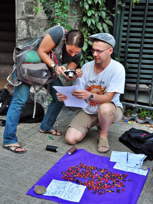 Kathrin lässt sich von einem deutschen Backpackertouristen das Glück der Runen lesen. Viele Langzeitreisende finanzieren sich ihre Reisen durch den Verkauf von Handgefertigtem auf der Straße. Das Gesetz toleriert es in vielen südamerikanischen Ländern.