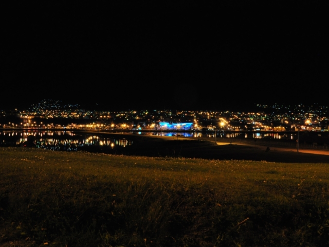 Wunderschöner Ausblick auf Ushuaia bei Nacht. Am Horizont erstreckt sich tiefschwarz der Beagle Kanal.