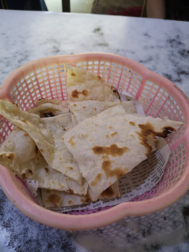 Naan-Brot frisch aus dem Ofen, ein Gaumenschmaus. Als Snack bestellt kann man oft wählen zwischen Knoblauch, Kräuter oder anderen Geschmacksrichtungen.