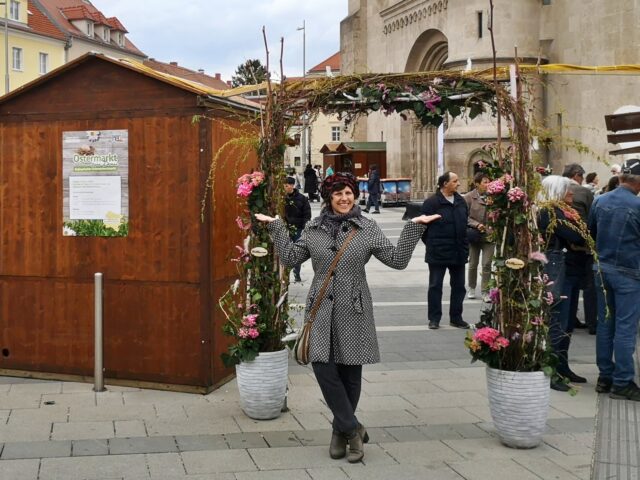 Ein wunderschöner Blumenkranz ziert den Eingang zum Ostermarkt. Im Hintergrund der beeindruckende Dom von Wiener Neustadt.