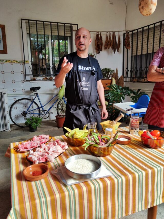 Miguel erklärt uns mit Herz und Leidenschaft, wie die Paella Valenciana zubereitet wird, was sie so besonders macht und ergänzt die kurze Therorieeinheit um ein paar interessante historische Geschichten rund um das typische Reisgericht.